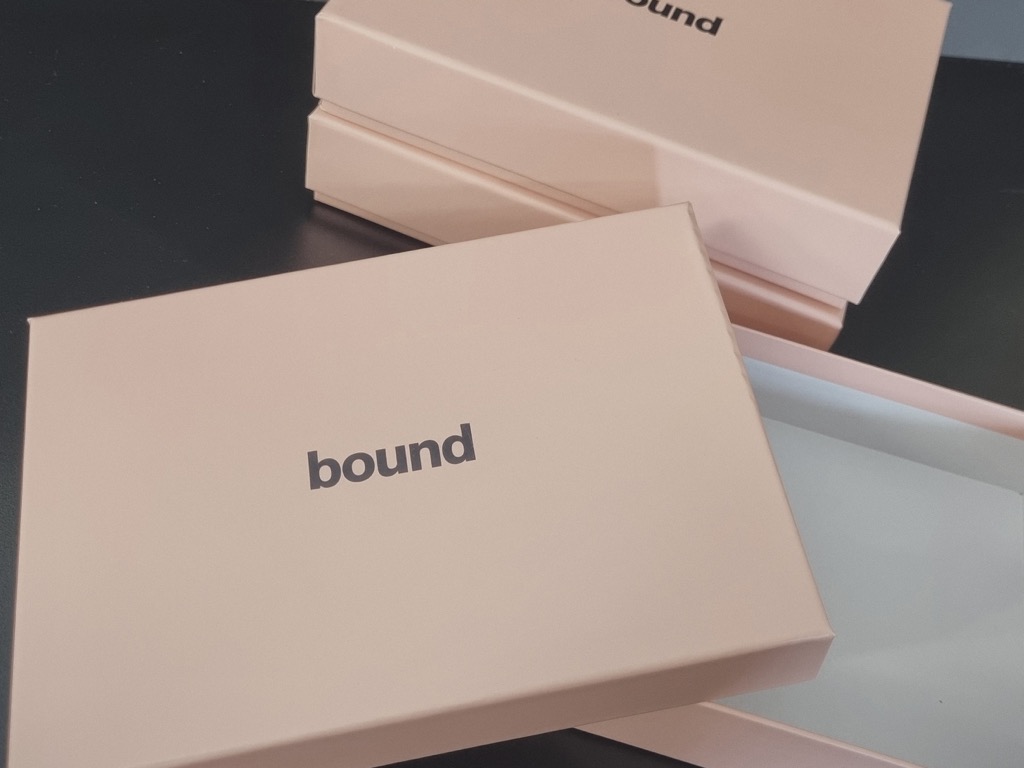 Blush litho-laminated rigid setup boxes, lids foiled in matt black.