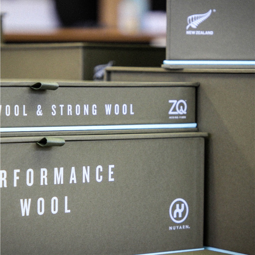 Stacked handmade wrapped rigid boxes in Colorplan Mid Green, printed in white ink with ribbon pulls on the lids.