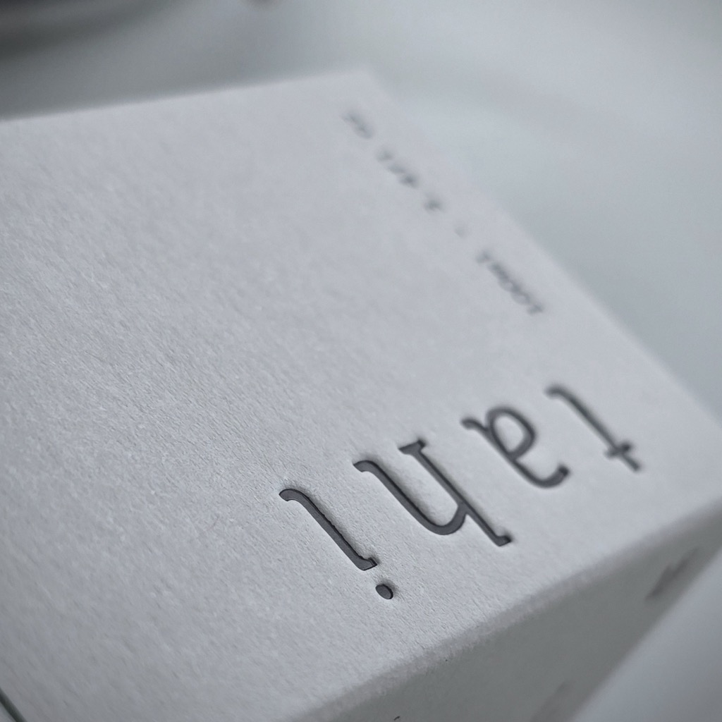 Tuck top carton in pale textured Colorplan Mist, the word tahi debossed into the lid.